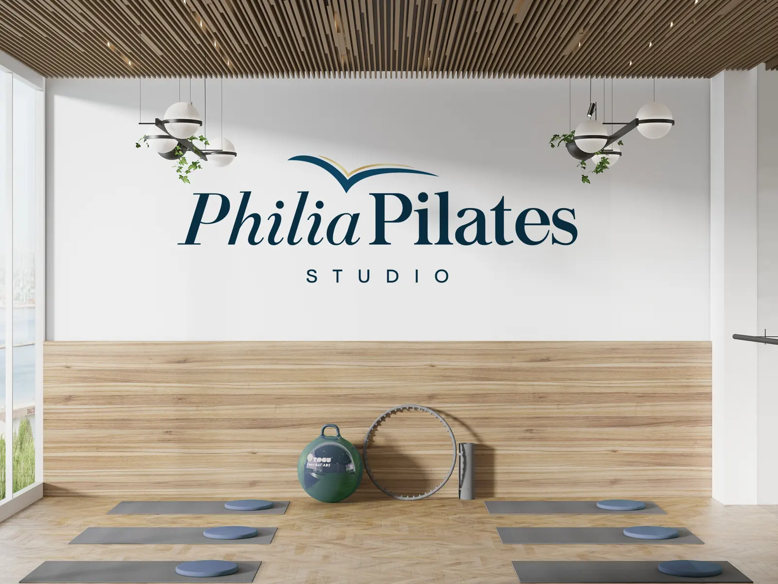 Parede da recepção com a marca Philia Pilates, diante da sala de solo